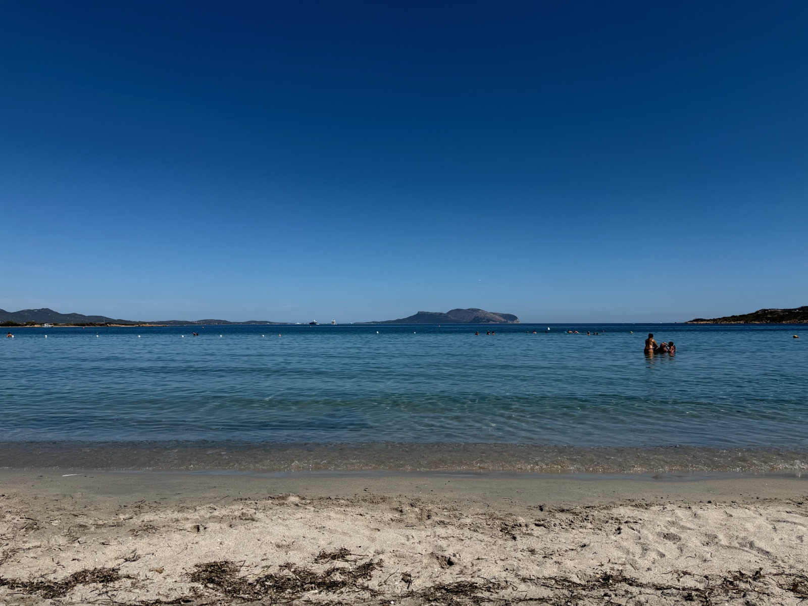 A calm sandy beach with shallow clear water in northeast Sardinia