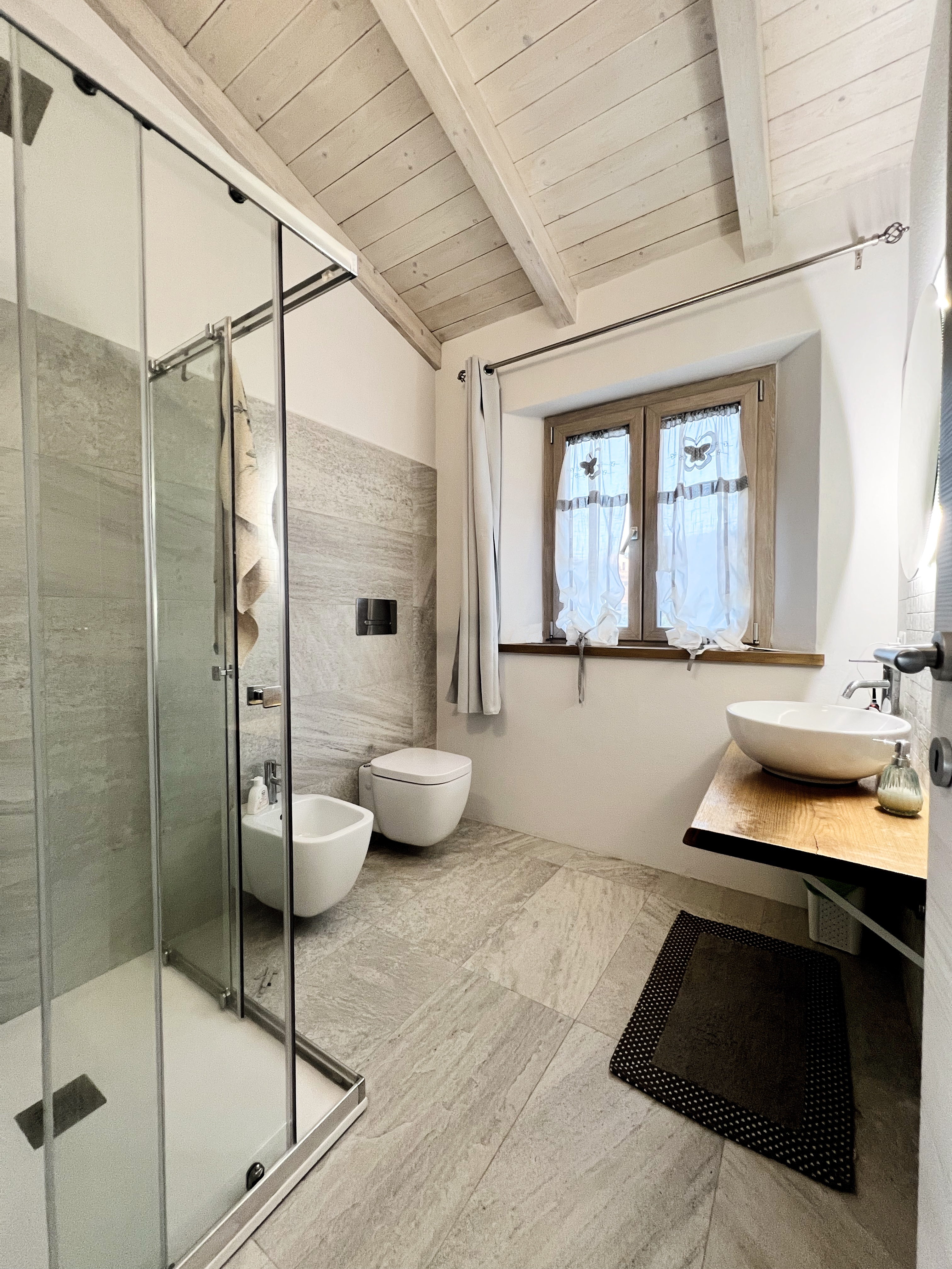Bagno di Villa Luce con doccia walk-in e finiture chiare e calme