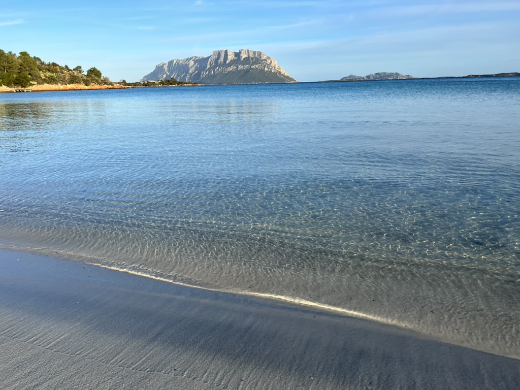 Clear shallow water at Porto Istana beach with Tavolara nearby