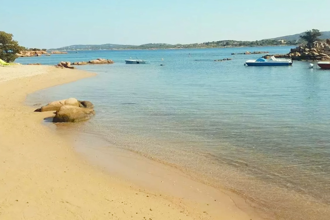 Spiaggia del Pescatore beach near Porto Istana with clear water and Tavolara beyond